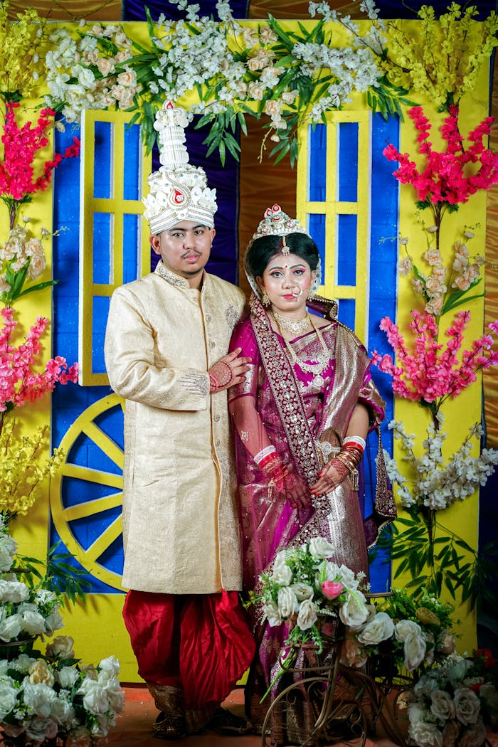 Captivating image of an Indian couple in traditional wedding attire with colorful floral decorations.