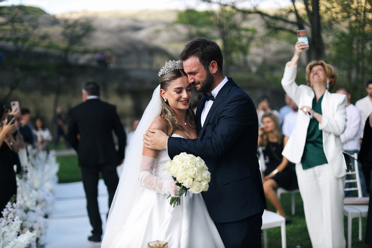 Beautiful outdoor wedding ceremony featuring a happy bride and groom embracing.